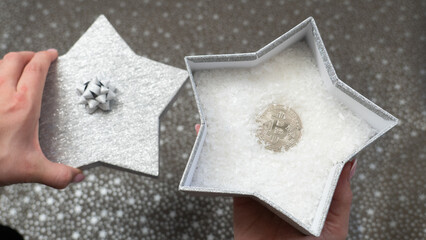 Way to give money as a gift. Giving bitcoin as a gift. A monetary gift in a silver shiny star box, stars pattern, silver bow