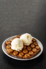 Hong Kong chocolate bubble waffle with ice cream on dark background with copy space.