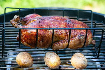 Chicken and potatoes baked and smoked on a kettle grill - 546923376