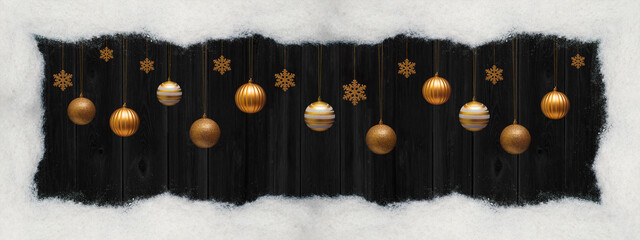 Christmas celebration holiday banner greeting card panorama background - Frame made of snow and hanging golden Christmas baubles balls and ice crystals, isolated on black wooden wall texture