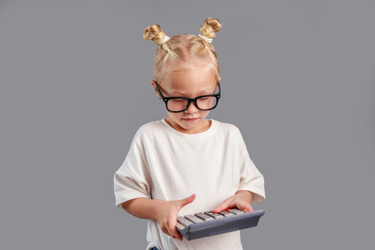 The girl counts on a calculator, complex math assignments at school, learning, back to school.
