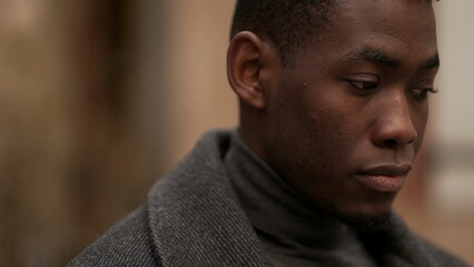 Fototapeta premium Contemplative young black man in meditative expression outside, close-up face