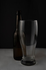 a bottle of beer and a glass on a black background