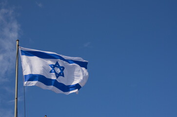 Flags of Israel in the wind. Beautiful blue sky. Star of David, blue and white flag of the State of Israel