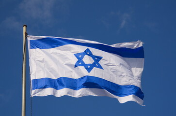 Fototapeta na wymiar Flags of Israel in the wind. Beautiful blue sky. Star of David, blue and white flag of the State of Israel