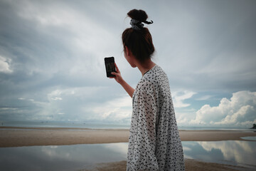 Young woman using smart phone on the beach