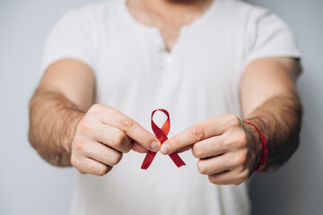 International AIDS Day. Man is holding red red ribbon. Promotes awareness. World Sexual Health Day.