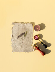 Wax printing with fire paint on homemade kraft paper with pressed dried flowers. Sealing wax seal...
