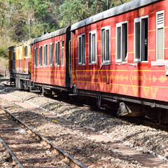 Toy Train moving on mountain slopes, beautiful view, one side mountain, one side valley moving on railway to the hill, among green natural forest. Toy train from Kalka to Shimla in India, Indian Train