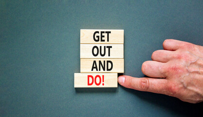 Motivational get out and do symbol. Concept words Get out and do on wooden cubes. Beautiful grey table grey background. Businessman hand. Business motivational get out and do concept. Copy space.