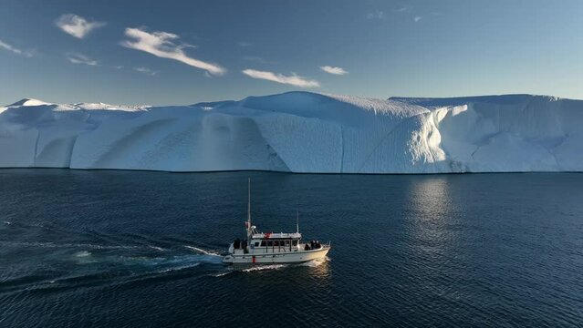 barco navegando cerca de grandes icebergs.