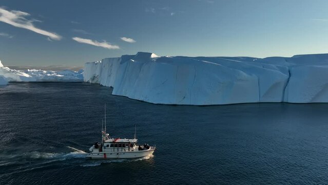 barco navegando cerca de grandes icebergs.