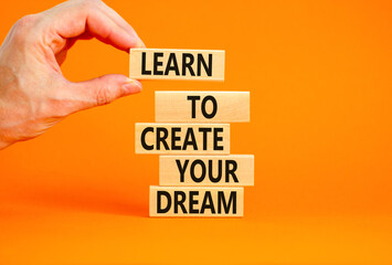 Create your dream symbol. Concept words Learn to create your dream on wooden blocks. Businessman hand. Beautiful orange table orange background. Business learn to create your dream concept. Copy space