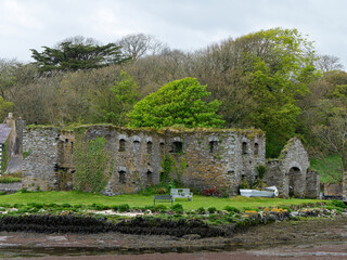 Fototapeta na wymiar The Arundel grain store, shore of Clonakilty Bay, spring. An old stone building in Ireland, Europe. Historical architectural monument, landscape. Tourist attractions in Ireland
