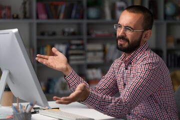 Bearded businessman working on computer in office. Video online webinar.