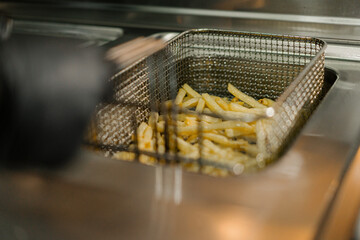 Close-up - the process of cooking french fries in a professional kitchen of a restaurant