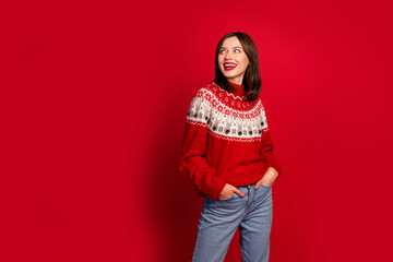 Portrait of attractive cheerful girl put arms pockets toothy smile look empty space isolated on red color background