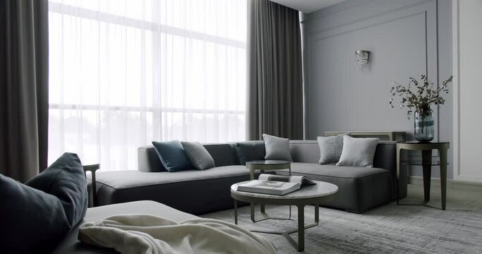 Modern contemporary Minimalist living room with gray furniture. Luxury Modern House Interior With Corner Sofa round table. Fashionable furniture. Minimalist Home Interior. Cozy Modern Furniture Design