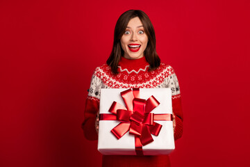 Fototapeta premium Photo of ecstatic overjoyed astonished girl with straight hairstyle wear red sweater hold gift box isolated on red color background