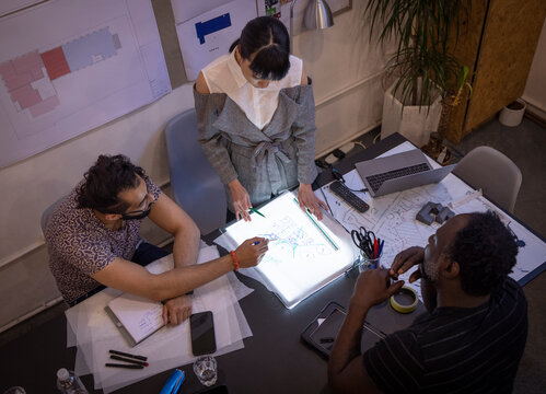Building designers planning, looking at diagram in meeting