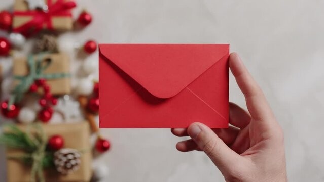 Hand holding a red letter to Santa Claus for Christmas background