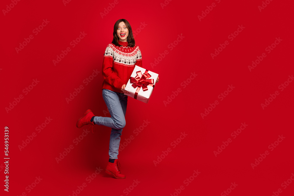 Sticker full length portrait of positive pretty person hands hold giftbox empty space ad isolated on red col