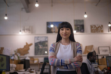 Portrait confident female designer standing in office