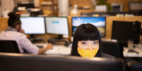 Portrait confident businesswoman in face mask working in office