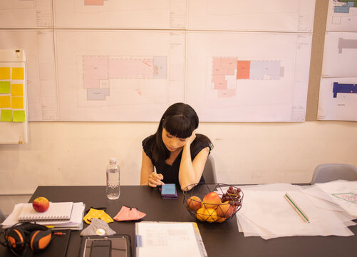 Female architect using smart phone in office