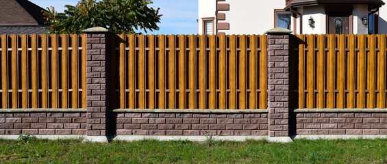 brown metal fence with brick posts