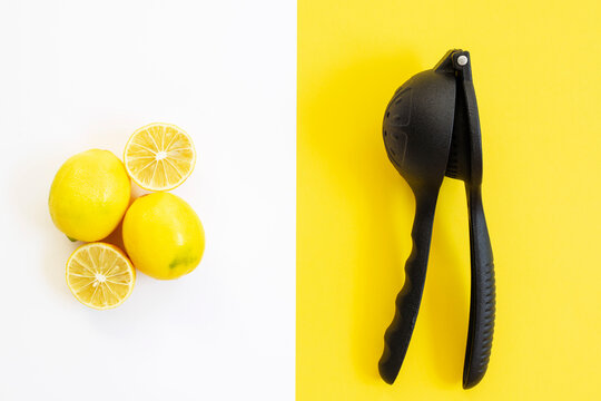 Lemon juicer and lemons on color background