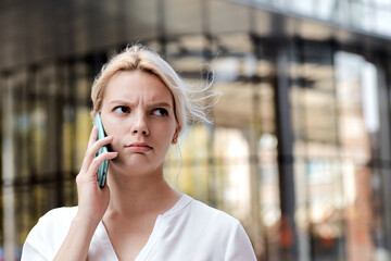 Professional business woman disapointed irritated girl talking to the mobile phone outside. Professional female talking the phone