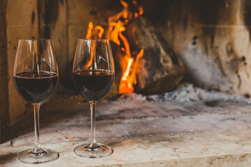 Taças de vinho tinto em lareira no inverno