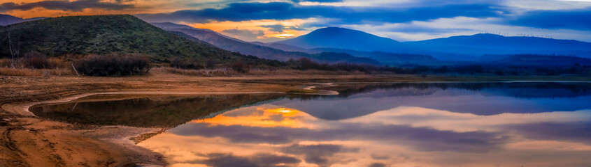 Fototapeta na wymiar sunset on lake, reflection of clouds on water