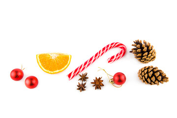Christmas decor: sweet stick, pine cones, orange and glass balls isolated on white background.