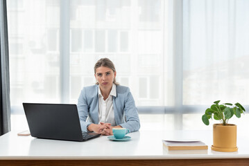 Fototapeta na wymiar Frustrated and angry freelancer businesswoman talking on video call, woman arguing and looking at laptop screen, online business conference. Female in smart casual wear sitting at office desk