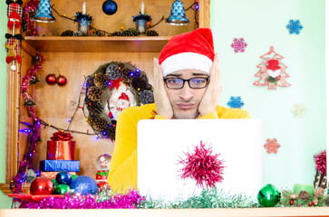 Shocked man wearing Santa hat and looking at laptop despite wonderful Christmas Day	
