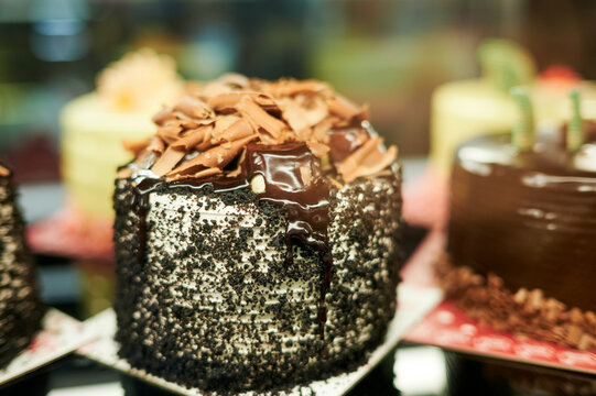 Delicious round cake in chocolate sprinkles under glaze