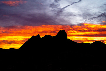 Orange cloudy sky with silhouette of a mountain