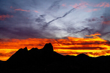 Orange cloudy sky with silhouette of a mountain
