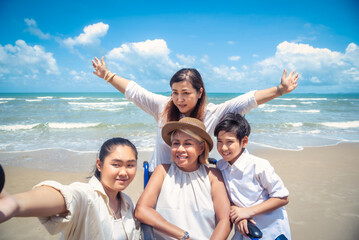 Fototapeta premium Happy Asian diversity generation family standing on tropical beach in summer at daytime