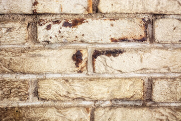Fragment of a wall made of old beige bricks for use as an abstract background and texture.