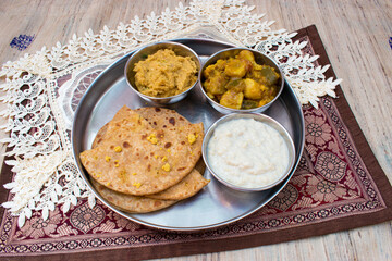 Dal Puri or dal stuffed paratha in plate and Gur kheer, Payasam, Phirni or rice pudding, mixed veg called dalna sabzi and oal chutney. Bihari thali .