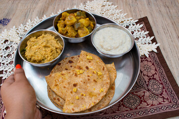 Dal Puri or dal stuffed paratha in plate and Gur kheer, Payasam, Phirni or rice pudding, mixed veg called dalna sabzi and oal chutney. Bihari thali .