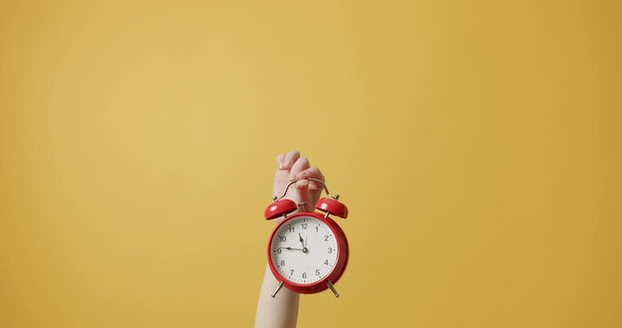 Alarm Time. Woman gesturing with her hands with Red alarm clock on isolated on yellow background. hurry up, relive it Woman Hands gestures, and shows that he must hurry. Retro Red Clock. 