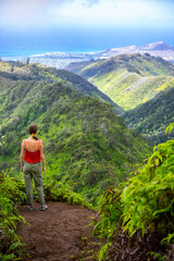hiker girl enjoys the panorama of oahu island and honolulu in hawaii islands while climbing wiliwilinui ridge trail; hiking on green mountains in hawaii, holidays in hawaii
