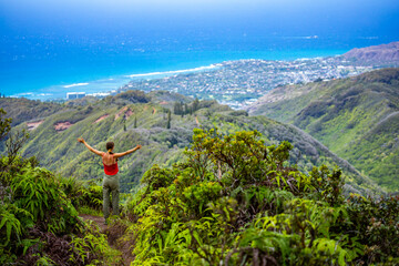 hiker girl enjoys the panorama of oahu island and honolulu in hawaii islands while climbing...