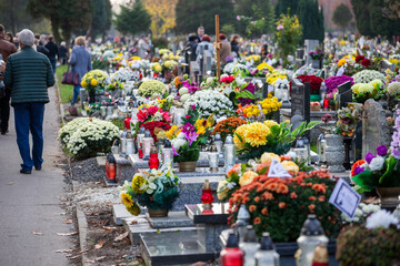 Groby na cmentarzu ze zniczami i kwiatami