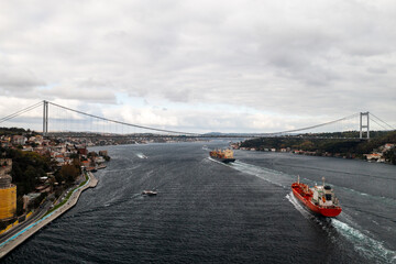 Tanker, cargo ship passes through the Bosporus. Awesome view of the Bosphorus Bridge (the 15 July...