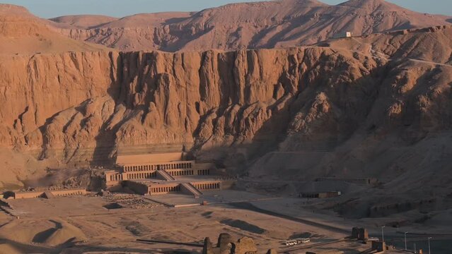 Drone shot over the Hatshepsut temple in Egypt with the mountain in the background, sunrise